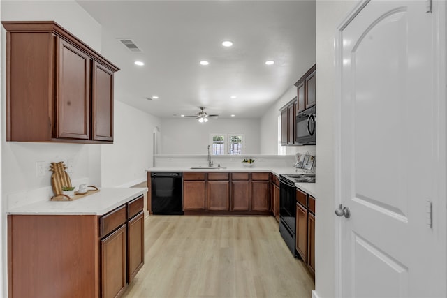 kitchen featuring ceiling fan, sink, kitchen peninsula, black appliances, and light wood-type flooring