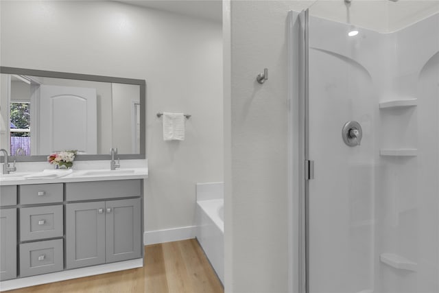 bathroom with shower with separate bathtub, vanity, and hardwood / wood-style flooring