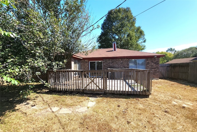 rear view of house featuring a deck and a yard