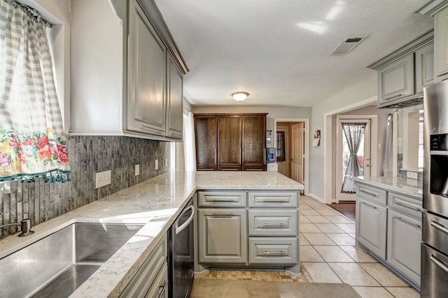 kitchen featuring stainless steel appliances, light tile patterned floors, backsplash, gray cabinetry, and sink