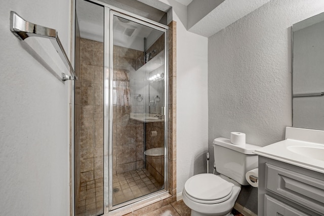 bathroom with toilet, tile patterned floors, a shower with shower door, and vanity