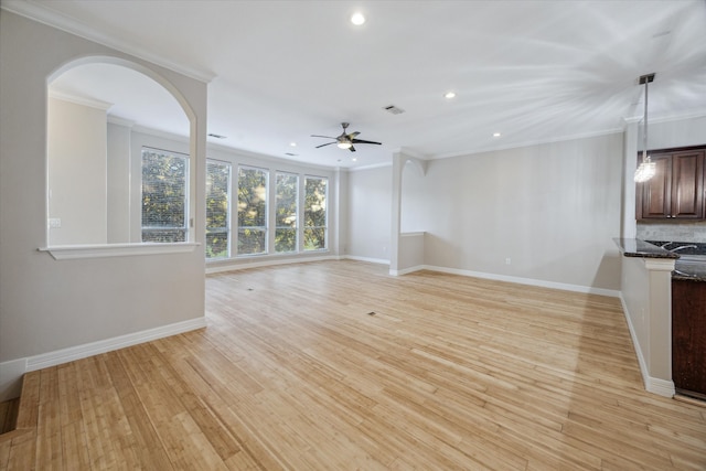 unfurnished living room featuring light hardwood / wood-style floors, ceiling fan, and crown molding