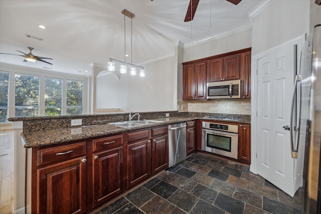 kitchen featuring sink, stainless steel appliances, decorative light fixtures, crown molding, and dark stone countertops