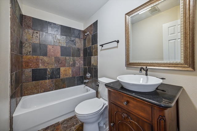 full bathroom with vanity, tiled shower / bath combo, toilet, and a textured ceiling