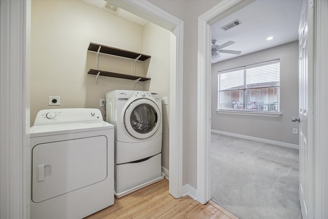 laundry area with light hardwood / wood-style flooring, ceiling fan, and washer and dryer