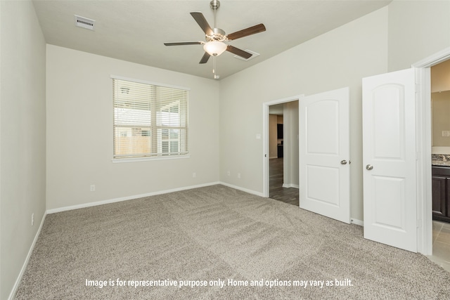 unfurnished bedroom with connected bathroom, ceiling fan, and light carpet