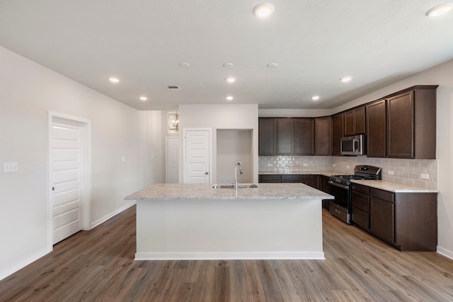 kitchen featuring stainless steel appliances, hardwood / wood-style floors, a kitchen island with sink, and sink