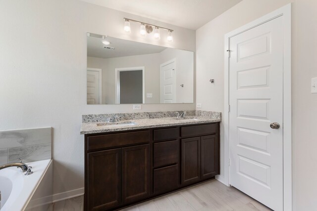 bathroom with a tub to relax in and vanity