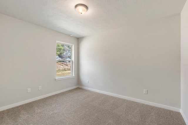 carpeted spare room featuring a textured ceiling