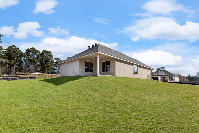 rear view of house featuring a lawn