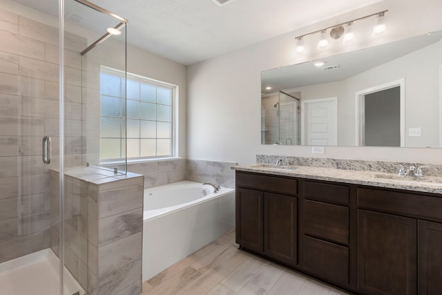 bathroom featuring vanity and separate shower and tub