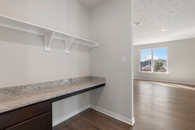 interior space with dark hardwood / wood-style flooring and built in desk