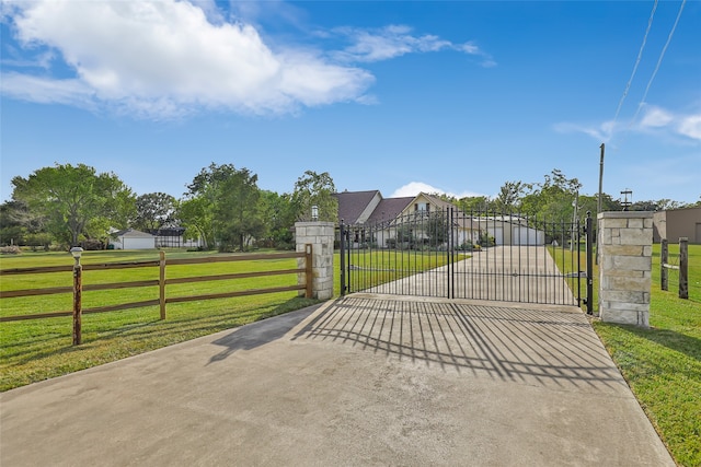 view of gate with a yard