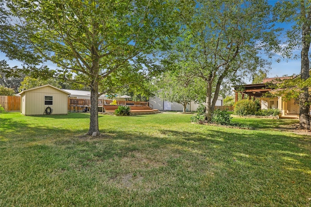 view of yard featuring a storage unit and a deck