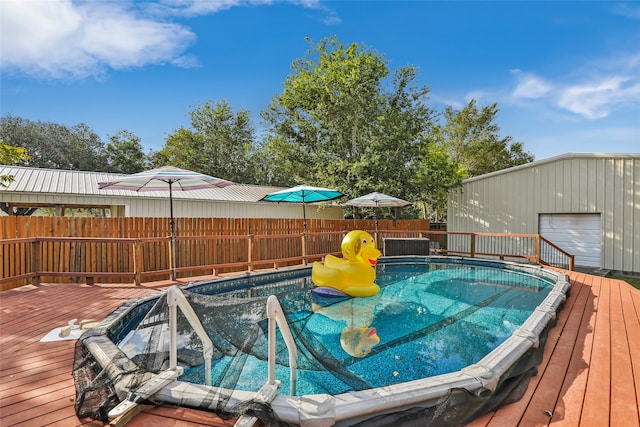 view of pool with an outbuilding, a deck, and a garage