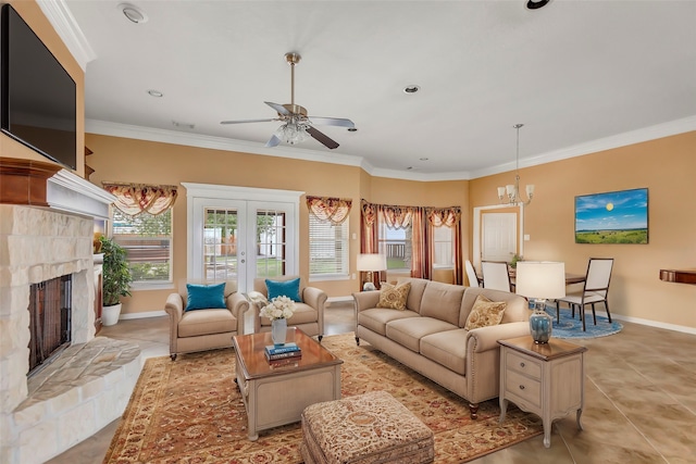 living room with a stone fireplace, light tile patterned flooring, ceiling fan with notable chandelier, and crown molding