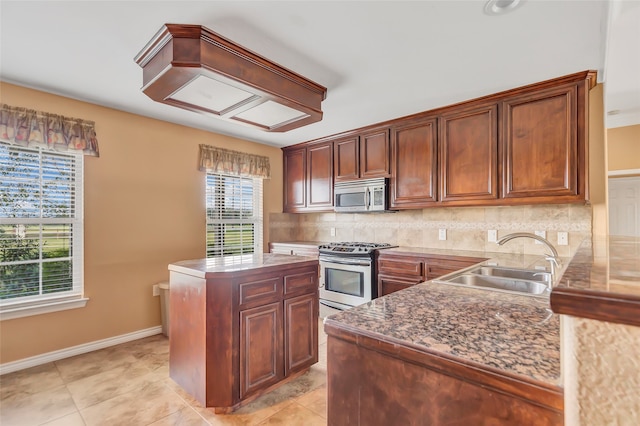 kitchen with a center island, sink, decorative backsplash, stainless steel appliances, and light tile patterned floors