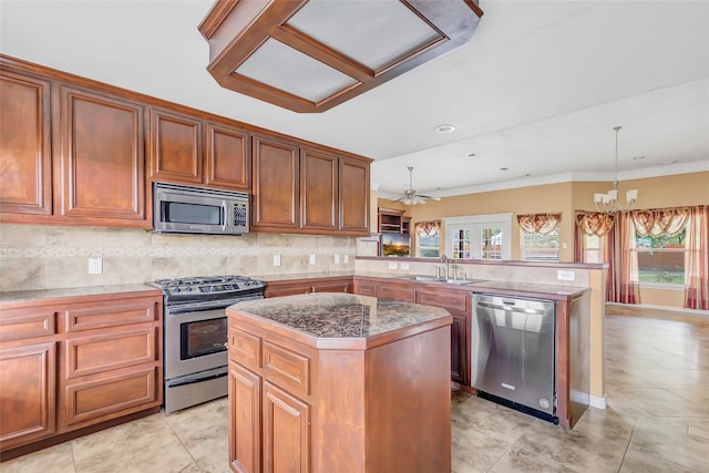 kitchen with appliances with stainless steel finishes, kitchen peninsula, a center island, and sink