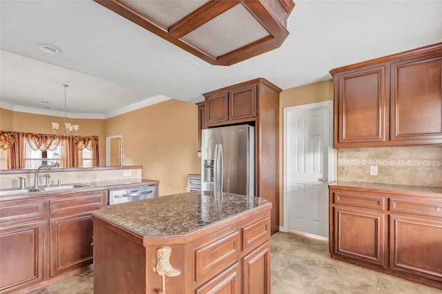 kitchen featuring ornamental molding, sink, stainless steel appliances, a center island, and an inviting chandelier