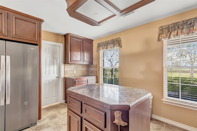 kitchen featuring a center island, plenty of natural light, tasteful backsplash, and stainless steel fridge