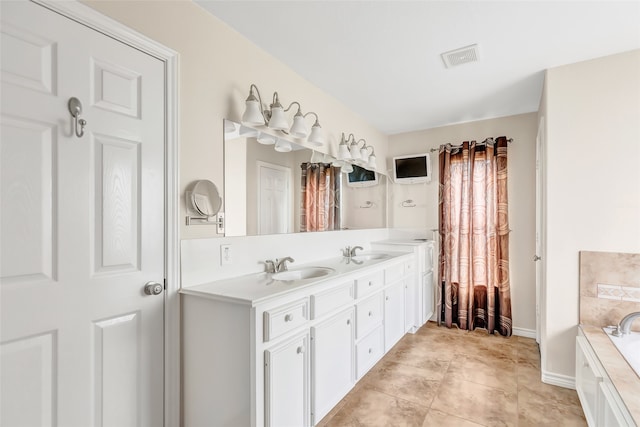 bathroom with vanity, a bathing tub, and tile patterned floors