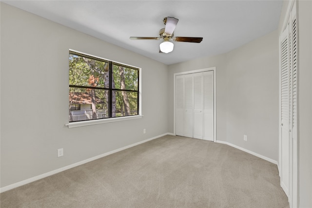 unfurnished bedroom with ceiling fan and light colored carpet