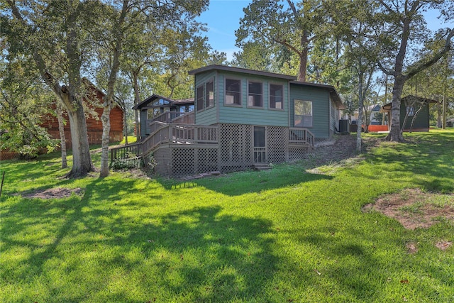 rear view of house with a lawn and a deck