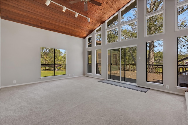 unfurnished sunroom featuring ceiling fan, wood ceiling, and plenty of natural light