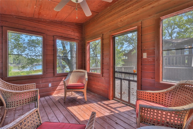 sunroom featuring wood ceiling, lofted ceiling, ceiling fan, and plenty of natural light