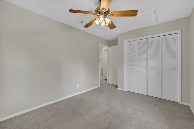 unfurnished bedroom with ceiling fan, light colored carpet, and a closet