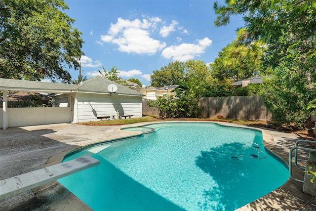 view of swimming pool featuring a diving board and a patio area