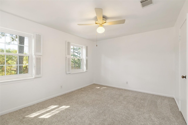 carpeted spare room featuring ceiling fan