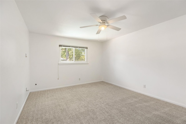 carpeted spare room featuring ceiling fan