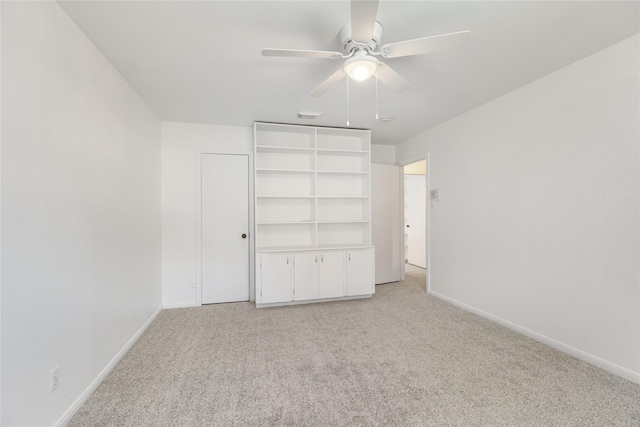 unfurnished bedroom with ceiling fan, light colored carpet, and a closet