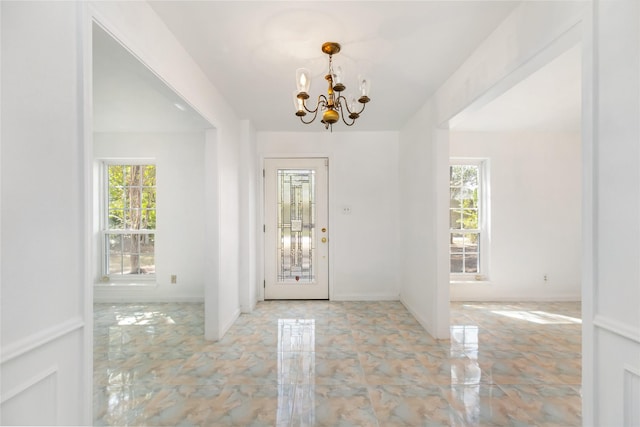 entryway with a wealth of natural light and a chandelier