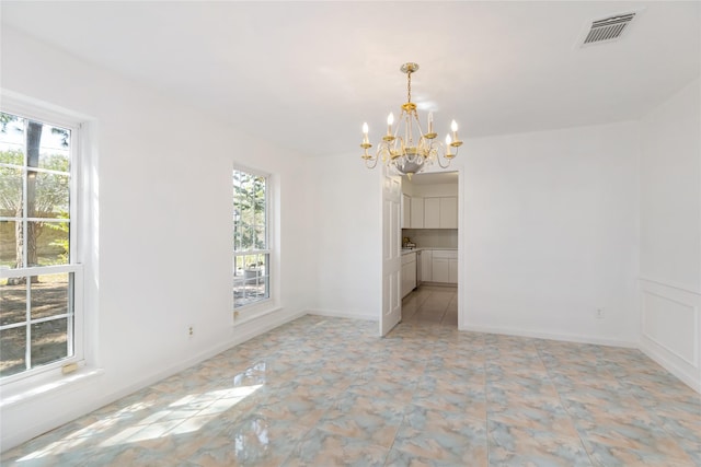 unfurnished dining area featuring an inviting chandelier