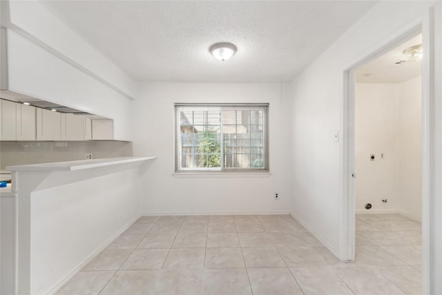 interior space with light tile patterned floors and a textured ceiling