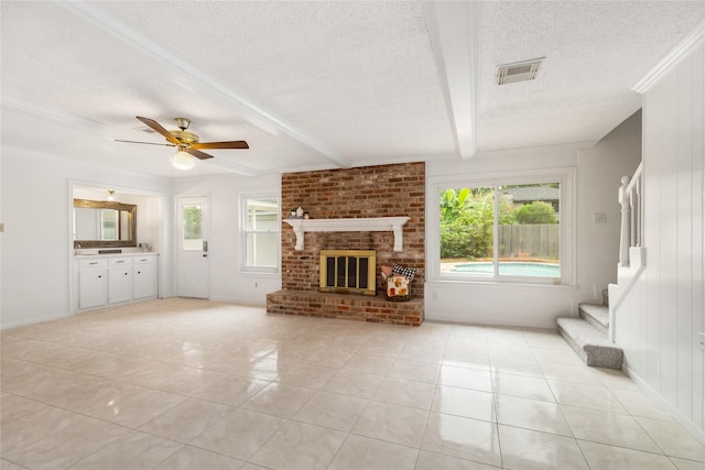 unfurnished living room with a fireplace, beam ceiling, a textured ceiling, and light tile patterned floors