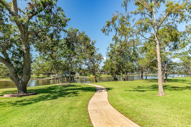 view of property's community with a yard and a water view