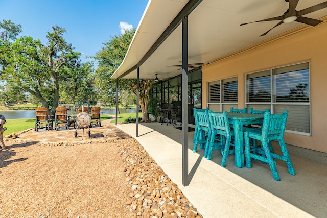 view of patio featuring a water view and ceiling fan