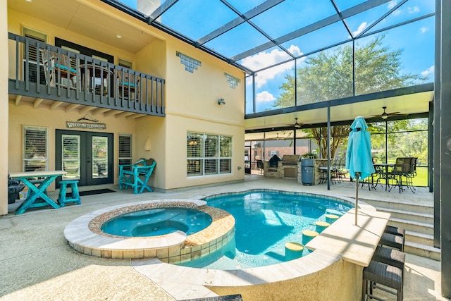 view of pool with french doors, an in ground hot tub, a patio, glass enclosure, and ceiling fan