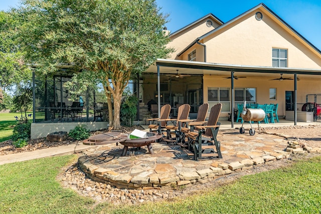 view of patio / terrace with a sunroom, ceiling fan, and a fire pit