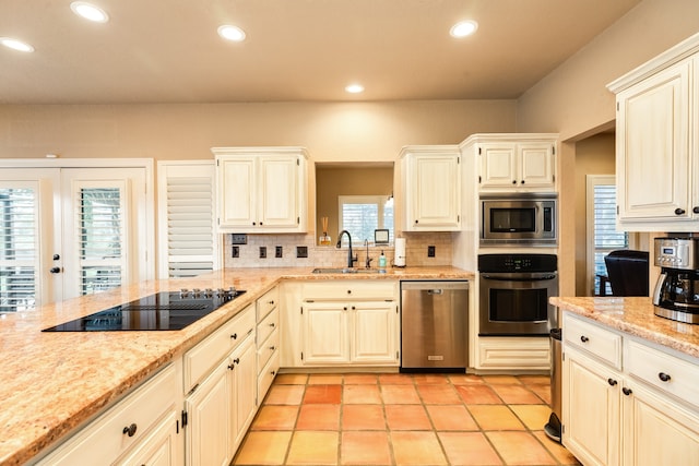 kitchen with decorative backsplash, light stone counters, light tile patterned floors, sink, and stainless steel appliances