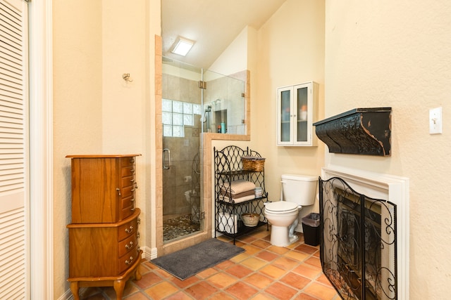 bathroom featuring a shower with door, toilet, and lofted ceiling