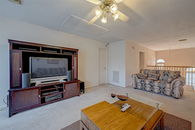 carpeted living room featuring ceiling fan and a textured ceiling