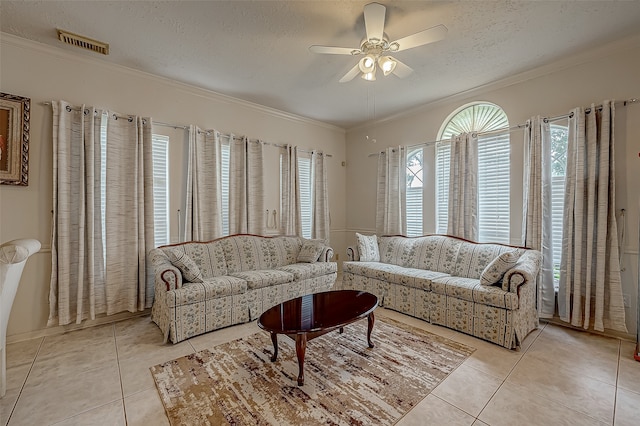 living room with ceiling fan, a textured ceiling, crown molding, and light tile patterned floors