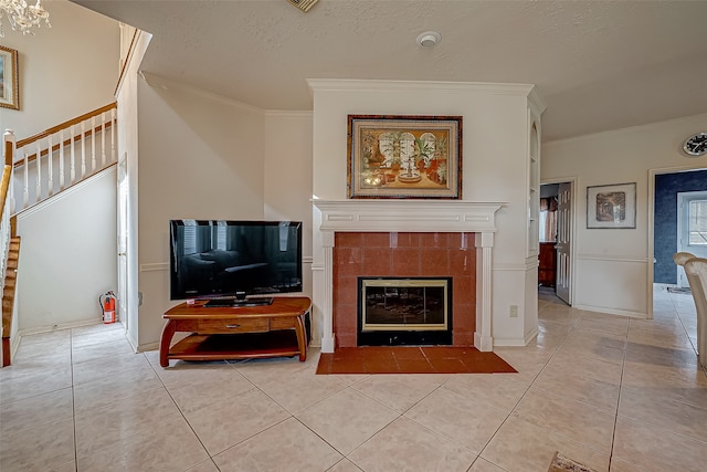 living room with light tile patterned flooring, a fireplace, and crown molding