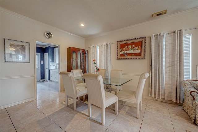 tiled dining space featuring ornamental molding