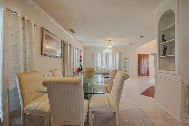 tiled dining area featuring ornamental molding, a textured ceiling, and ceiling fan