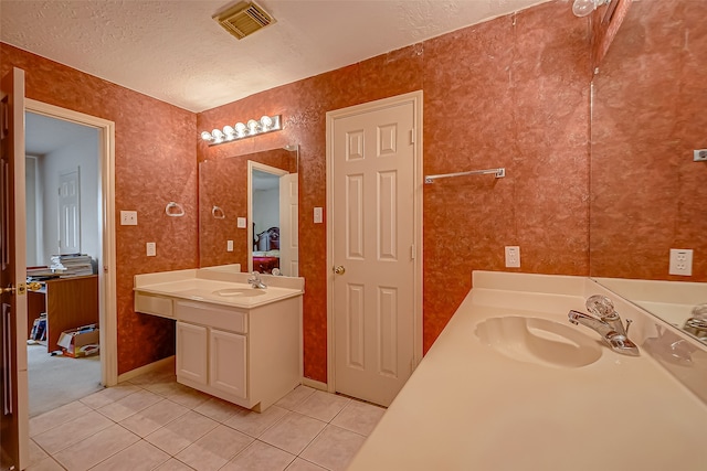 bathroom featuring vanity, a textured ceiling, and tile patterned floors